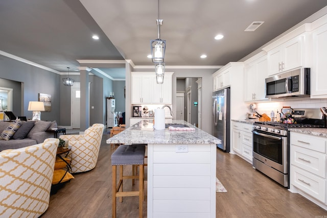 kitchen featuring a center island with sink, pendant lighting, and appliances with stainless steel finishes