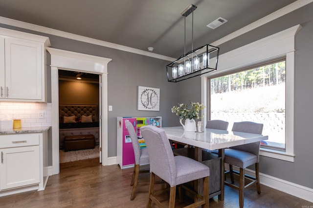 dining room featuring dark hardwood / wood-style flooring and ornamental molding