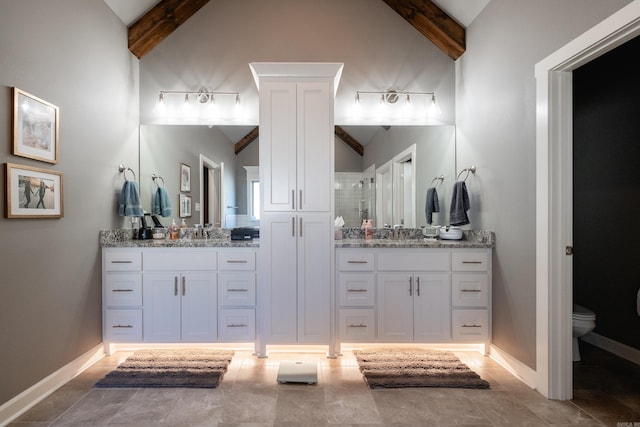 bathroom featuring vanity, lofted ceiling with beams, and toilet