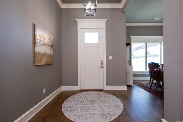 foyer entrance featuring dark hardwood / wood-style floors, a healthy amount of sunlight, and ornamental molding