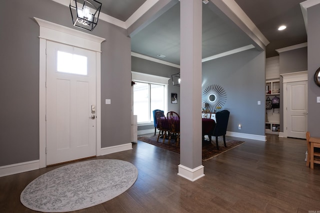 foyer with dark wood-type flooring and ornamental molding