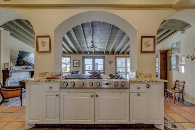 kitchen with white cabinets, ceiling fan, kitchen peninsula, and stainless steel gas cooktop