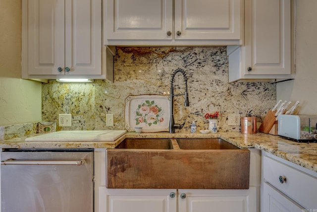 kitchen featuring decorative backsplash, white cabinetry, stainless steel dishwasher, and sink