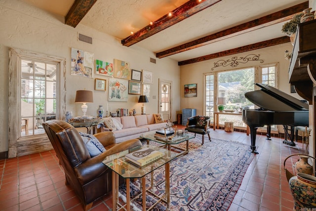 living room with tile patterned flooring, beam ceiling, a textured ceiling, and ceiling fan