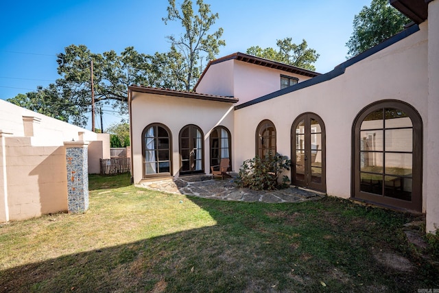 rear view of house with a yard and french doors