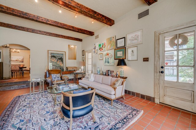 tiled living room with beamed ceiling and track lighting