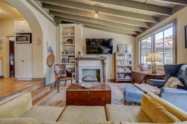 living room featuring lofted ceiling with beams, wood ceiling, and a tiled fireplace