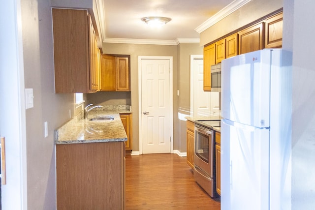 kitchen featuring crown molding, sink, light hardwood / wood-style flooring, stainless steel appliances, and light stone counters