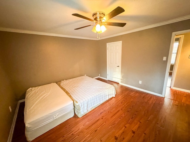 unfurnished bedroom with ceiling fan, hardwood / wood-style floors, and crown molding