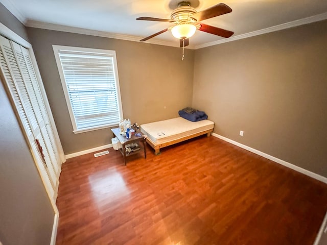 unfurnished bedroom with ceiling fan, wood-type flooring, and crown molding