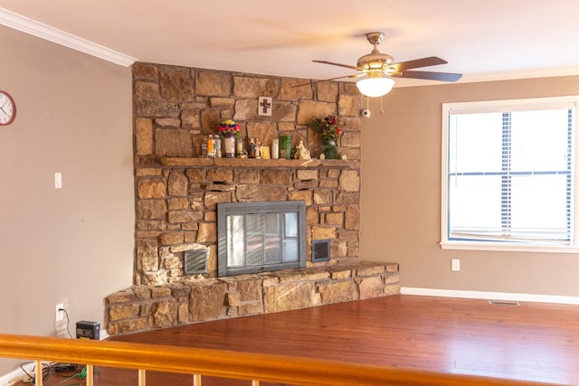 unfurnished living room featuring a fireplace, wood-type flooring, ceiling fan, and ornamental molding