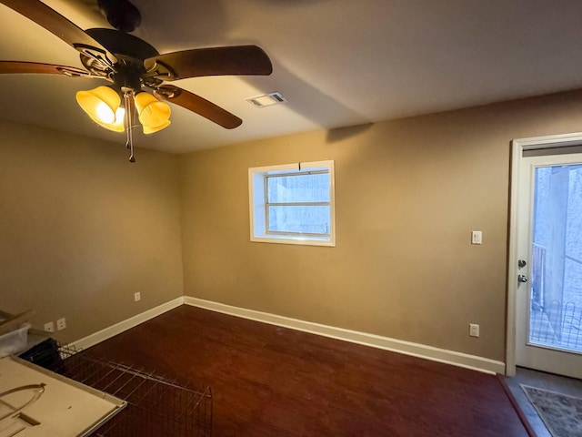 spare room featuring dark wood-type flooring and ceiling fan