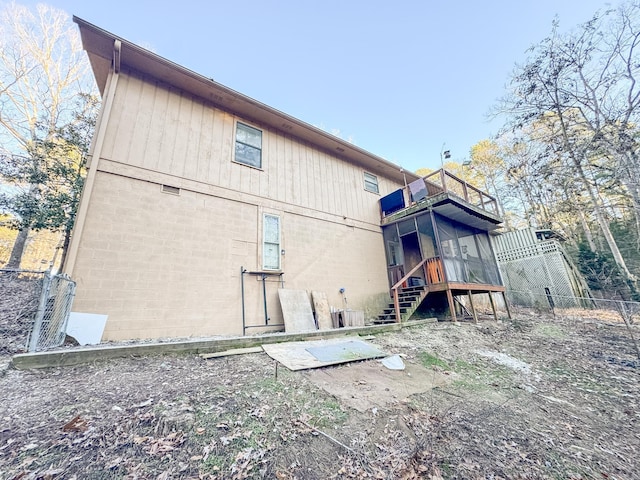 back of property with a balcony and a sunroom