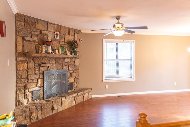 living room with ceiling fan, dark hardwood / wood-style flooring, ornamental molding, and a fireplace