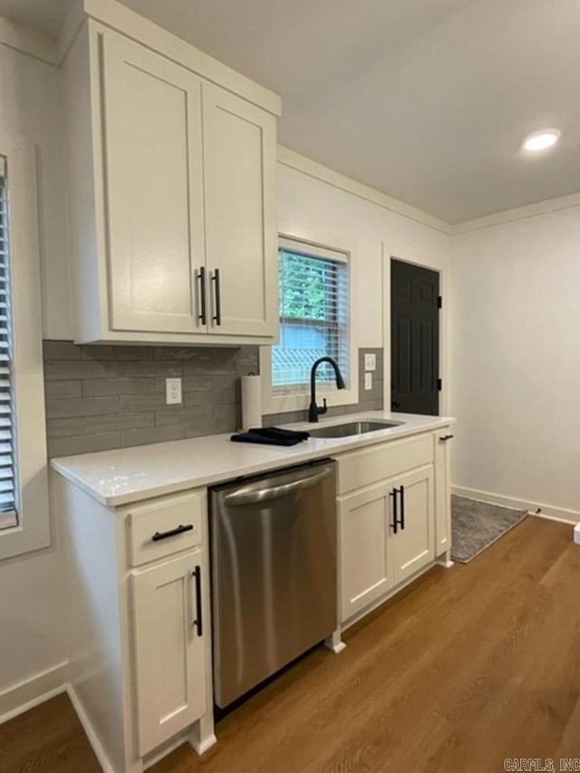 kitchen with stainless steel dishwasher, decorative backsplash, white cabinets, and wood-type flooring