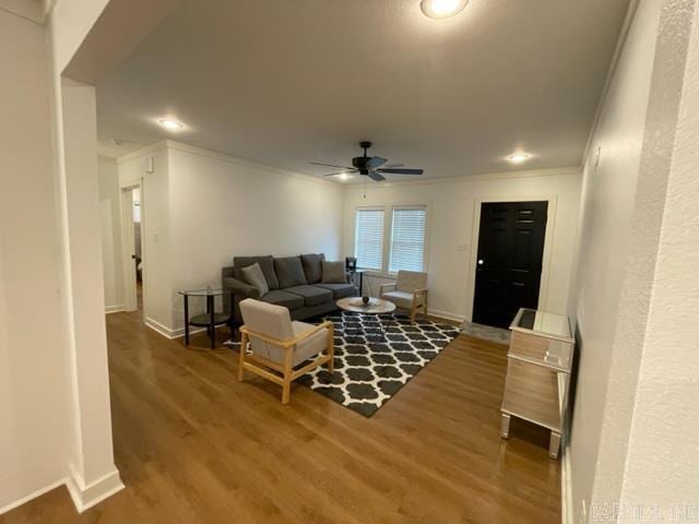 living room featuring ceiling fan, wood-type flooring, and ornamental molding