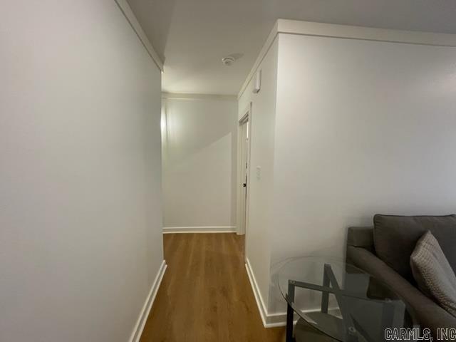 hallway featuring dark hardwood / wood-style floors and ornamental molding