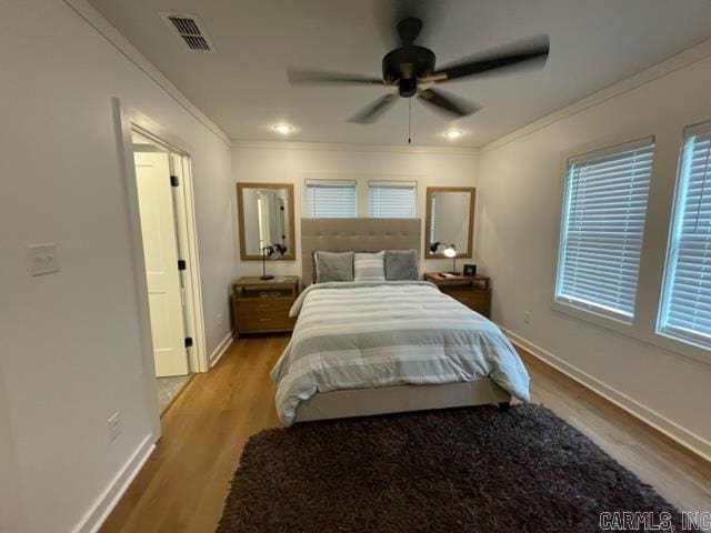 bedroom with light wood-type flooring, ceiling fan, and ornamental molding