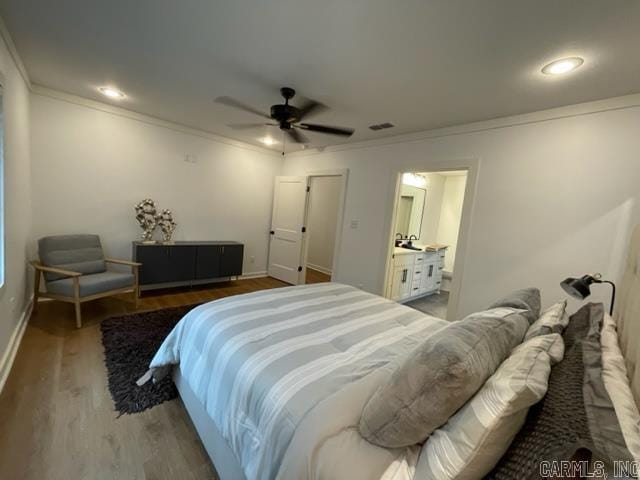 bedroom with hardwood / wood-style flooring, ceiling fan, crown molding, and ensuite bath