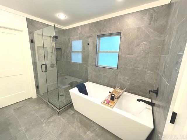 bathroom featuring independent shower and bath