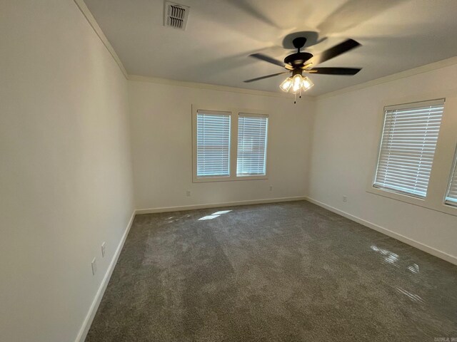 spare room with dark carpet, ceiling fan, and crown molding