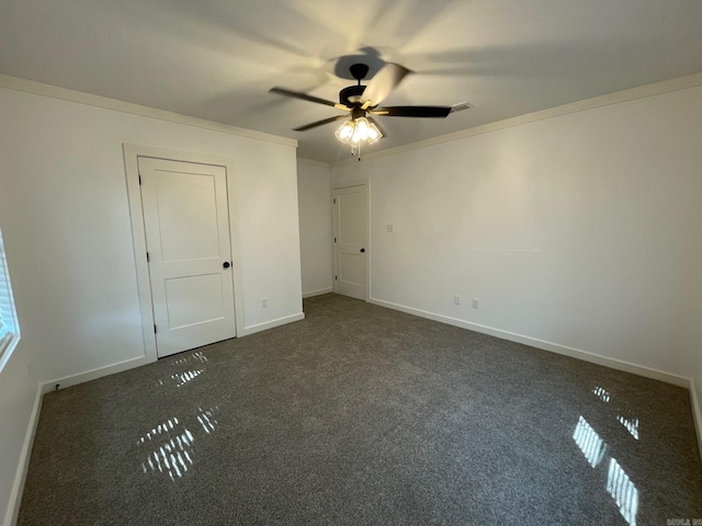 unfurnished bedroom with dark colored carpet, ceiling fan, and ornamental molding