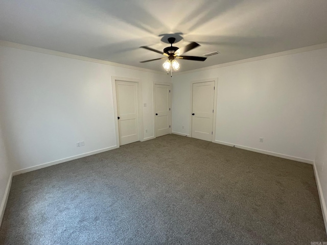 unfurnished room with ceiling fan, dark colored carpet, and ornamental molding