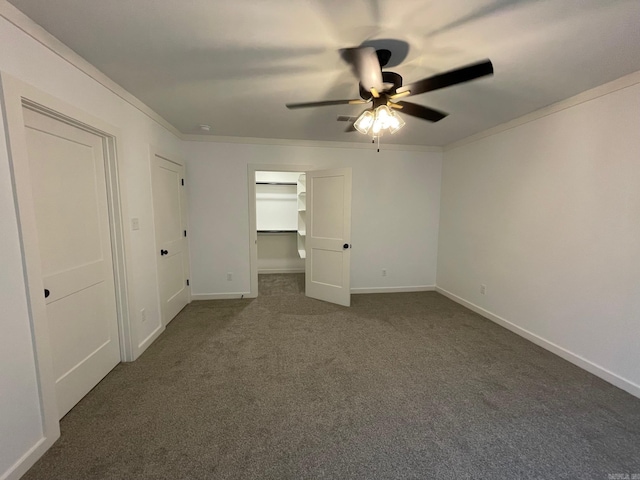 unfurnished bedroom featuring ceiling fan, dark carpet, and ornamental molding