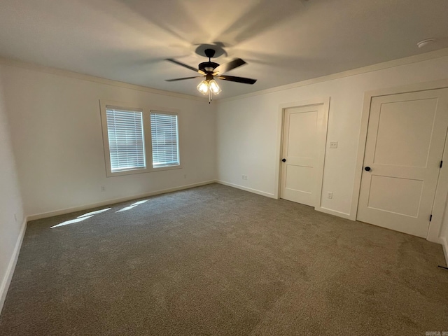 carpeted empty room featuring ceiling fan and crown molding