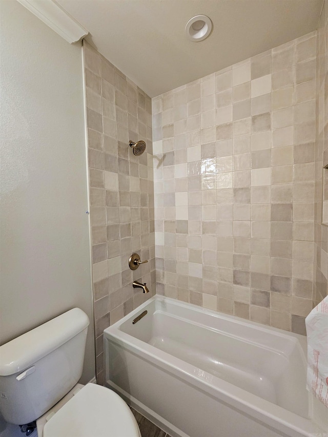 bathroom featuring tiled shower / bath and toilet