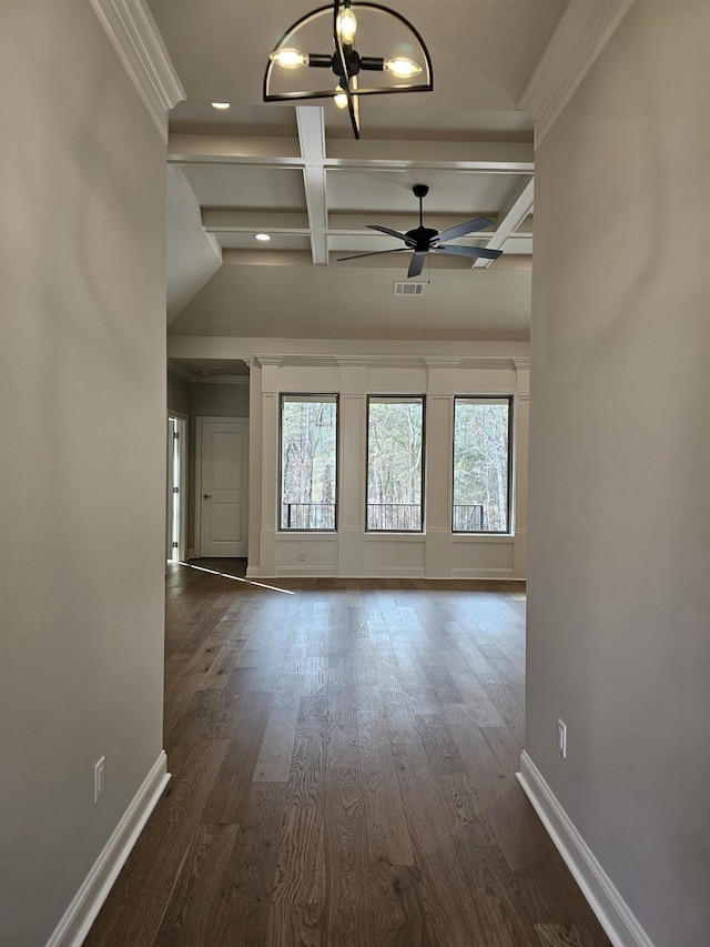 empty room with beamed ceiling, plenty of natural light, coffered ceiling, and dark hardwood / wood-style floors