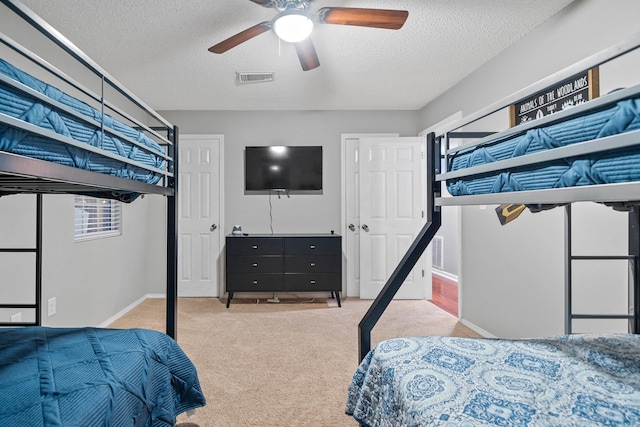 carpeted bedroom featuring a textured ceiling and ceiling fan