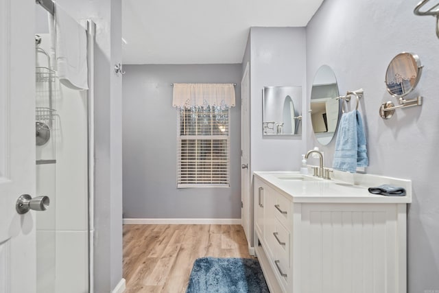 bathroom featuring vanity, hardwood / wood-style flooring, and a shower with door