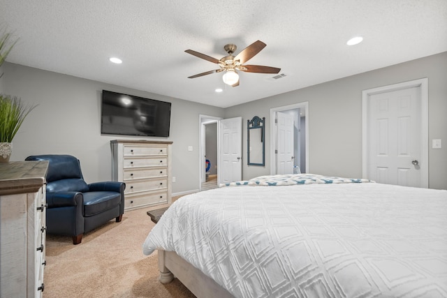 bedroom with ceiling fan, a textured ceiling, and light carpet