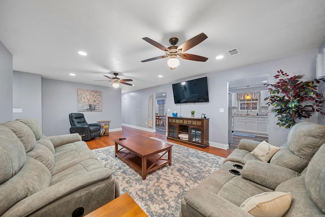 living room with wood-type flooring, ceiling fan, and sink