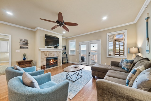 living room featuring a fireplace, ornamental molding, light hardwood / wood-style floors, and a healthy amount of sunlight