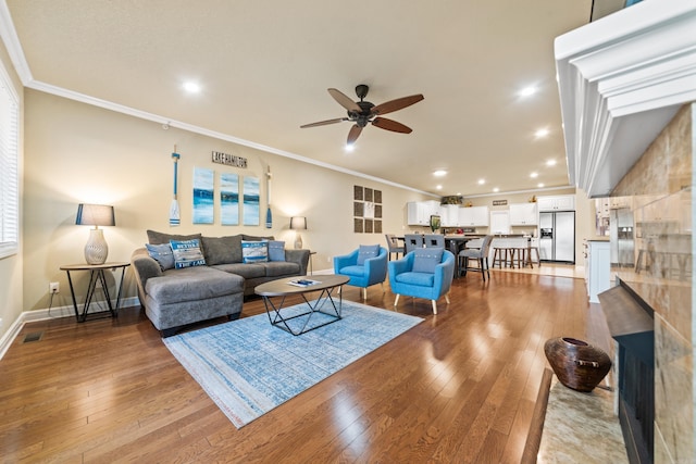 living room featuring ceiling fan, light wood-type flooring, and crown molding