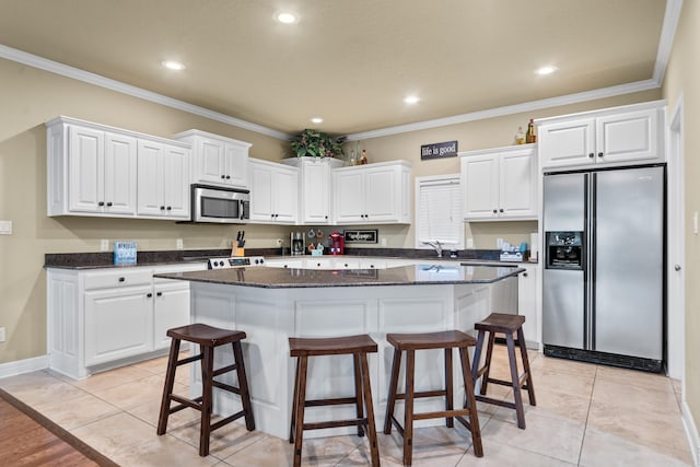 kitchen featuring white cabinetry, a center island, light tile patterned floors, and stainless steel appliances