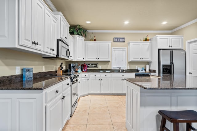 kitchen featuring white cabinets, appliances with stainless steel finishes, light tile patterned floors, and crown molding