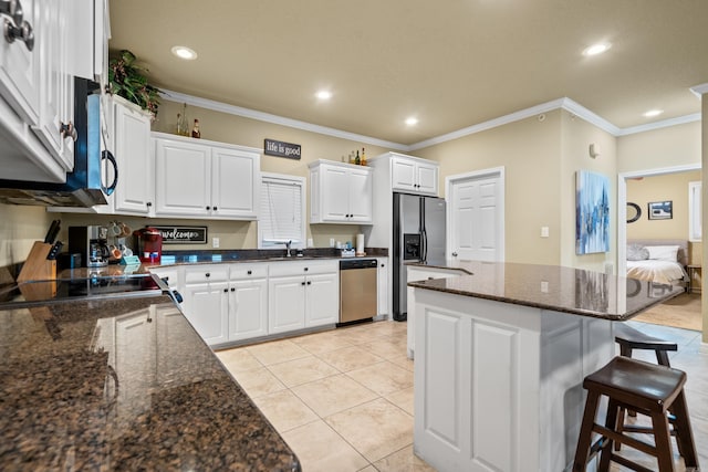 kitchen featuring crown molding, light tile patterned floors, a kitchen island, white cabinetry, and stainless steel appliances