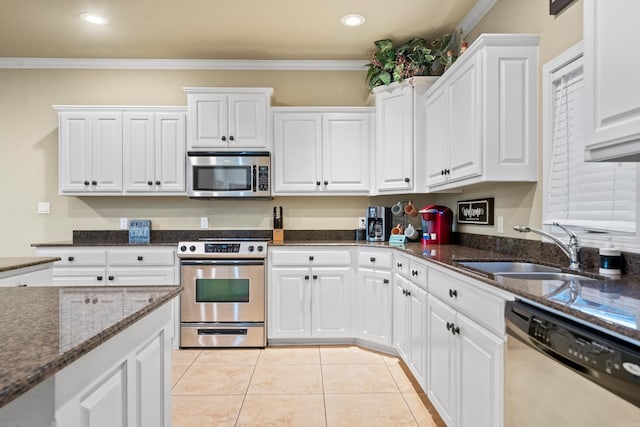 kitchen featuring appliances with stainless steel finishes, white cabinetry, crown molding, and sink