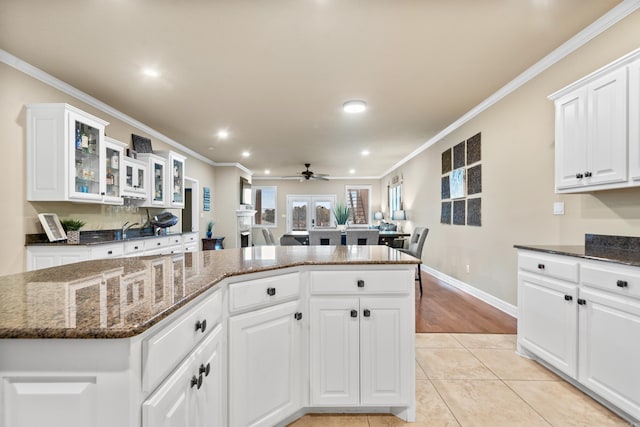 kitchen featuring white cabinets, dark stone countertops, light tile patterned floors, and french doors