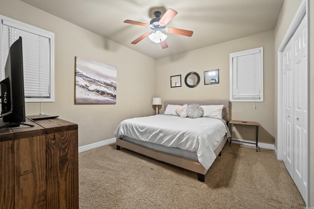 carpeted bedroom with ceiling fan and a closet