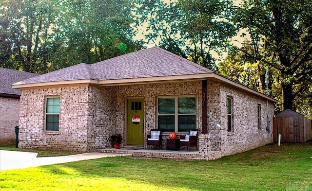 view of front of property with an outdoor living space, a front lawn, and a storage shed