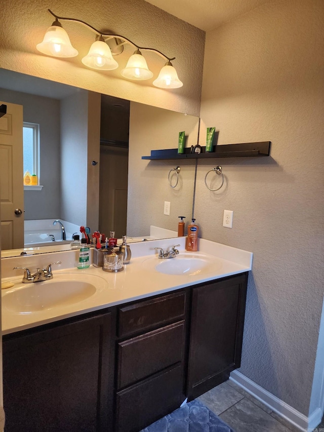 bathroom with a washtub, vanity, and tile patterned floors