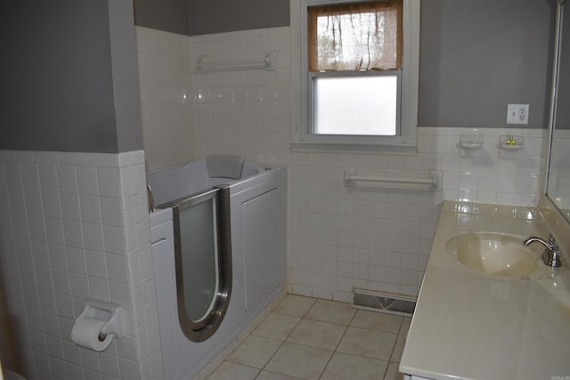 bathroom with tile patterned flooring, vanity, and tile walls