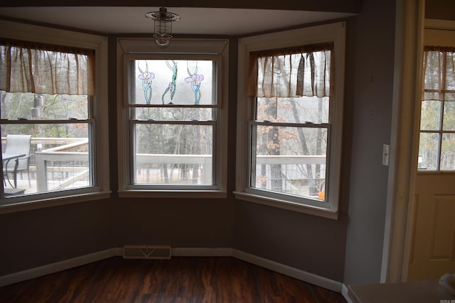 unfurnished dining area featuring dark hardwood / wood-style flooring