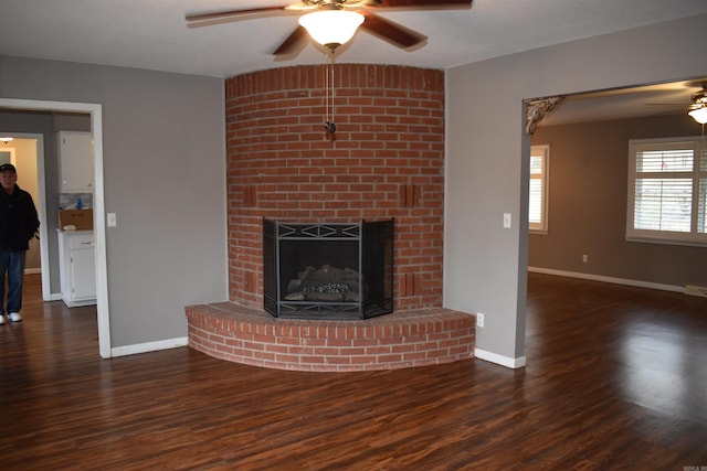 unfurnished living room with ceiling fan, dark hardwood / wood-style floors, and a fireplace