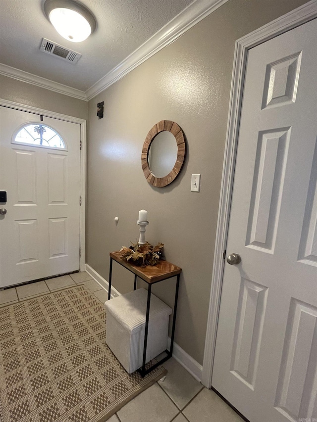 foyer featuring a textured ceiling, light tile patterned flooring, and crown molding