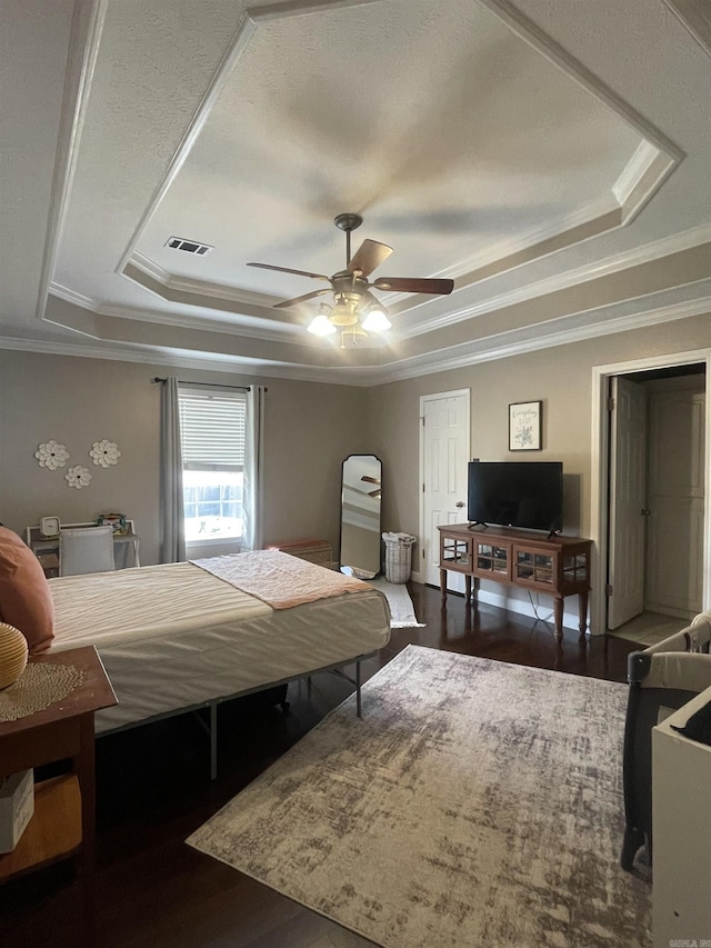 bedroom featuring ceiling fan, a raised ceiling, and crown molding